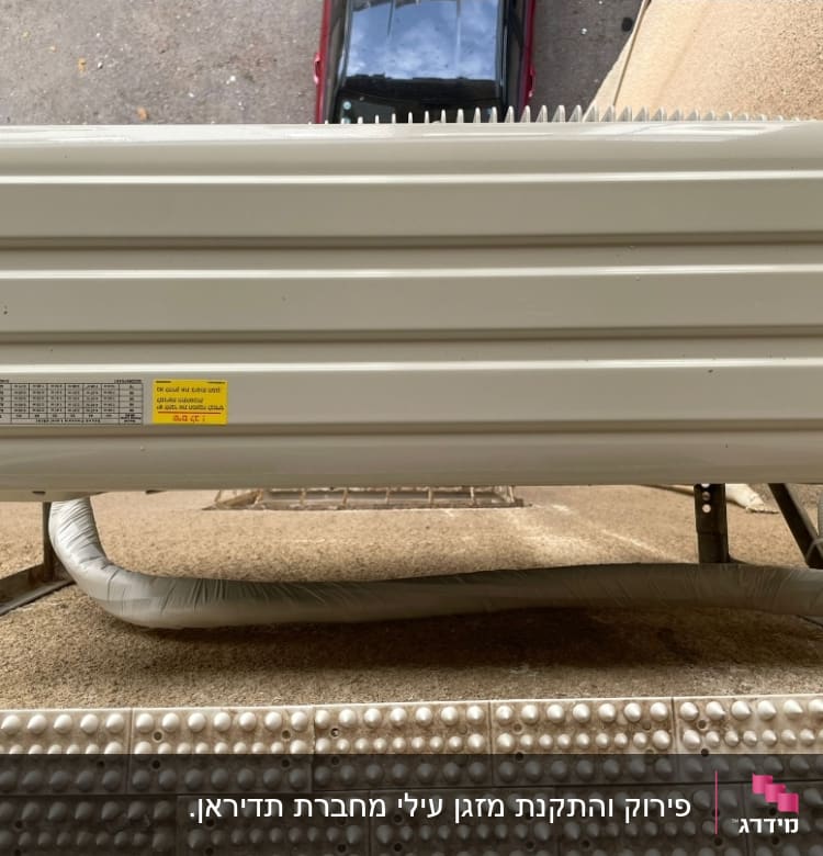 יחידת מזגן חיצונית מותקנת על קיר עם צינור מחובר
